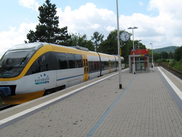 Bahnhof Bad Holzhausen Ein moderner Zug hält am barrierefreien Bahnsteig des Bahnhofs Bad Holzhausen unter bewölktem Himmel.