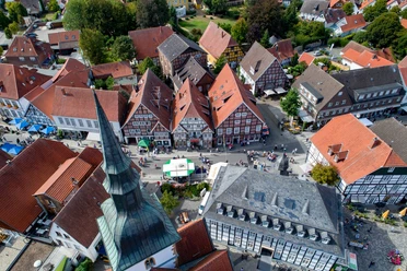 Luftansicht Historischer Stadtkern Luftaufnahme von historischen Fachwerkhäusern einer charmanten Altstadt mit Menschen auf der Straße.