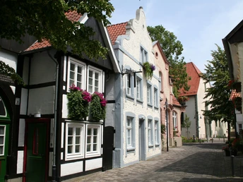Klosterstraße Historische Fachwerkhäuser mit blumengeschmückten Fenstern in einer malerischen Kopfsteinpflastergasse.