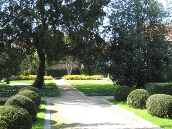 Drostengarten Ein gepflegter Park mit grüner Rasenfläche, Gehwegen und blühenden Beeten, umgeben von Bäumen.