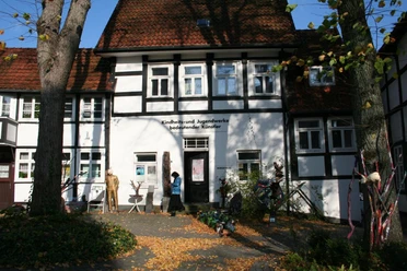 Fachwerkhaus mit "Kindheits- und Jugendwerke bedeutender Künstler" in herbstlicher Parkanlage.