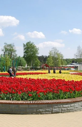 Gartenschaupark Rietberg Eingangsbereich Mitte/Historischer Stadtkern Ein weitläufiger Garten mit bunten Tulpenbeeten unter einem klaren, blauen Himmel im Frühling.