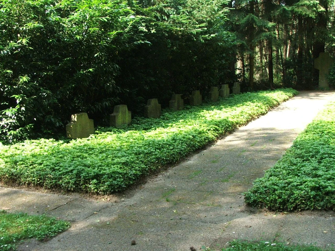 Soldatenfriedhof 1 Soldatenfriedhof mit Reihen von Grabsteinen, umgeben von dichtem Grün in einer ruhigen Waldumgebung.