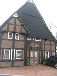 Fachwerkhaus Rhienstraße 32 Fachwerkhaus mit auffälligem steilen Schieferdach, schmalen Fenstern und bemalten Backsteinmustern.