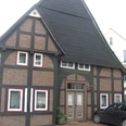 Fachwerkhaus Rhienstraße 32 Fachwerkhaus mit auffälligem steilen Schieferdach, schmalen Fenstern und bemalten Backsteinmustern.