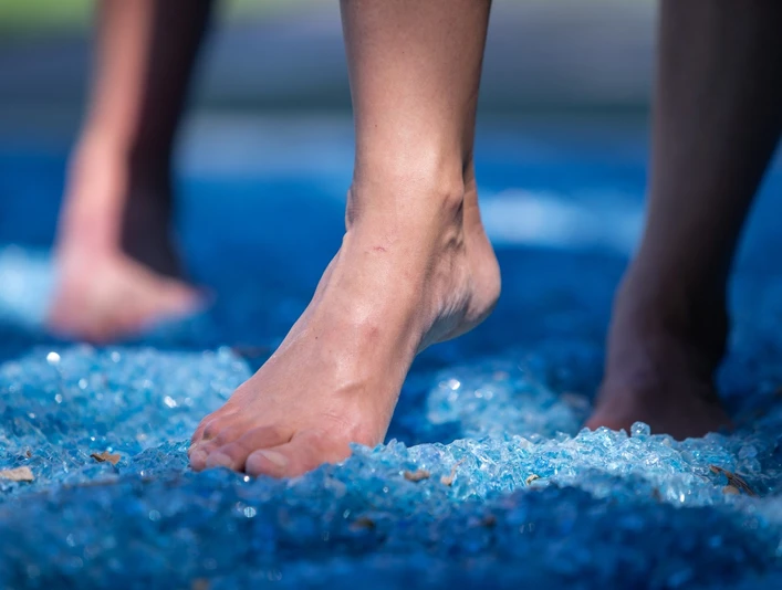 Kneipp-Pfad im Erlebnis- & Gesundheitspark Bad Salzuflen Barfuß gehen auf blauen Glasscherben im Kneipp-Pfad, fördert Balance und Fußreflexzonenmassage.
