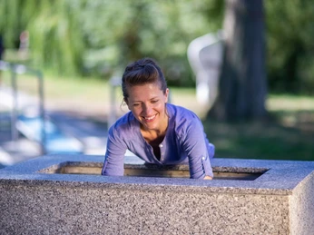 Kneipp-Armbecken im Erlebnis- & Gesundheitspark Bad Salzuflen Person taucht lächelnd Arme in ein Kneipp-Becken im Erlebnis- und Gesundheitspark.