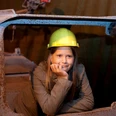 Besucherbergwerk Kleinenbremen Mädchen mit Helm in Waggon eines Besucherbergwerks, lächelnd nachdenklich in der Kohlemine.