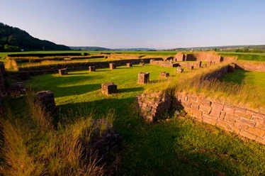 Überreste einer Klosterruine in Höxter, umgeben von Wiesen und sanften Hügeln bei Sonnenuntergang.