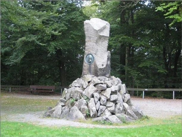 Bismarckstein Steinerne Gedenksäule im Wald zu Ehren von Otto von Bismarck, umgeben von Bäumen und Kiesweg.