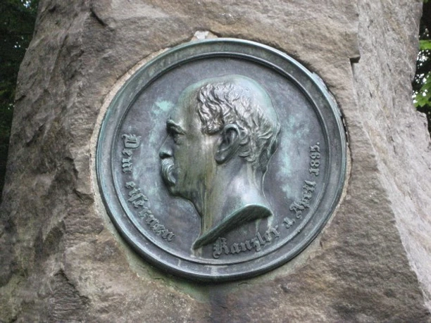 Gedenkstein aus robustem Stein mit einem kreisförmigen, detaillierten Relief-Porträt von Otto von Bismarck.