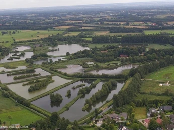 Naturschutzgebiet Rietberger Fischteiche Luftaufnahme einer weitläufigen Teichlandschaft mit grünen Feldern im Hintergrund.