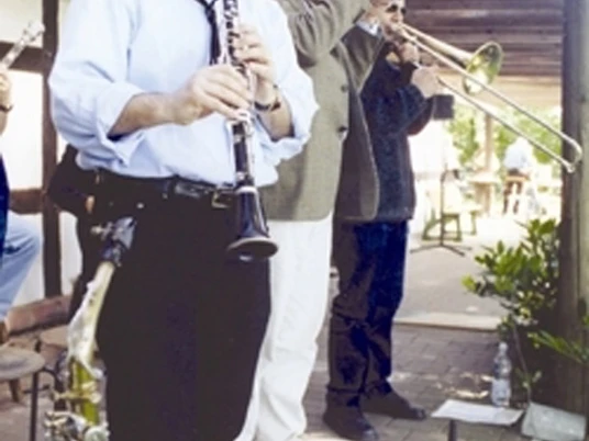 Kultur und gute Laune für die ganze Familie im Farmhouse Jazzclub Drei Musiker spielen im Freien auf einer überdachten Terrasse Klarinette und Trompete.