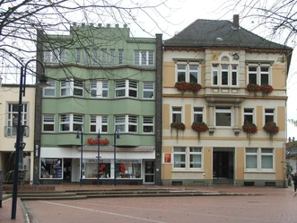 Rathaus II Zwei historische Gebäude nebeneinander, das linke in Pastellgrün, das rechte in Sandfarben gehalten.