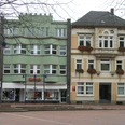 Rathaus II Zwei historische Gebäude nebeneinander, das linke in Pastellgrün, das rechte in Sandfarben gehalten.