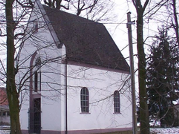 Die Lindenkapelle in Bad Lippspringe, von Bäumen umgeben, präsentiert sich im winterlichen Gewand.