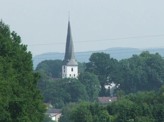 Dorfkirche Heiden Die Dorfkirche Heiden mit ihrem spitzem Turm ist von üppigem Grün umgeben und durch Bäume eingebettet.