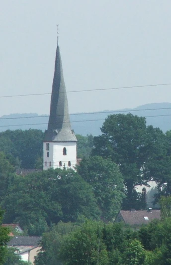 Dorfkirche Heiden Die Dorfkirche Heiden mit ihrem spitzem Turm ist von üppigem Grün umgeben und durch Bäume eingebettet.