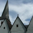 Dorfkirche Heiden Gothische Dorfkirche mit markantem schlanken Turm und drei Giebeln unter blauem Himmel.