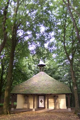 Hungerbergkapelle Historische Kapelle im Grünen, umgeben von hohen Bäumen, mit markantem, rundem Dach.