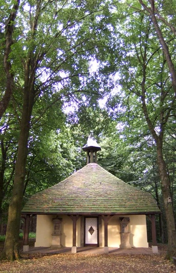 Hungerbergkapelle Historische Kapelle im Grünen, umgeben von hohen Bäumen, mit markantem, rundem Dach.
