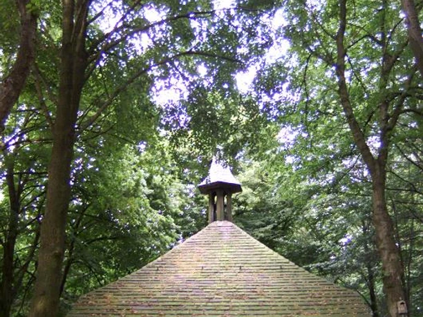 Hungerbergkapelle Historische Kapelle im Grünen, umgeben von hohen Bäumen, mit markantem, rundem Dach.