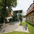 Malerischer Kunsthausgarten Moderne Glasfassade verbindet historische Fachwerkgebäude in gepflegter Parklandschaft.