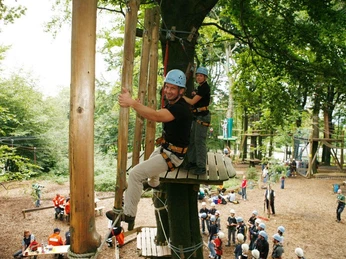 Kletterpark am Hermannsdenkmal Menschen in einem Kletterpark genießen Seilbahnen zwischen hohen Bäumen bei sonnigem Wetter.