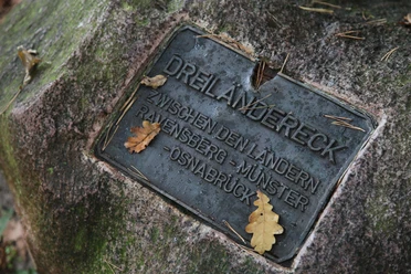 Steinplatte markiert das Dreiländereck zwischen Ravensberg, Münster und Osnabrück mit Eichenblättern.