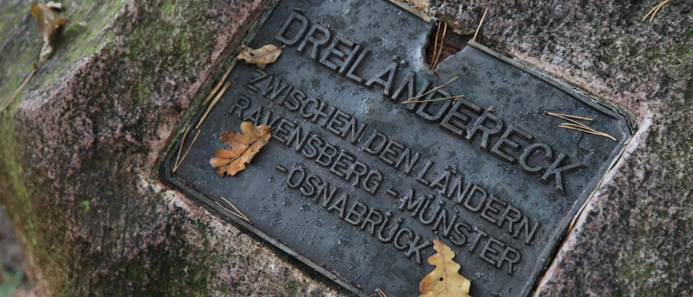 Dreiländereck Steinplatte markiert das Dreiländereck zwischen Ravensberg, Münster und Osnabrück mit Eichenblättern.