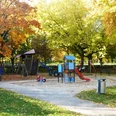 Spielplatz am Maspernplatz Spielplatz am Maspernplatz mit Rutsche, Klettergerüst, Wipptier, umgeben von herbstlichen Bäumen.