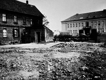 Das dritte Rathaus, ab 1947 Historisches Rathaus von 1947, umgeben von Schutt und Trümmern in einer einfachen städtischen Umgebung.