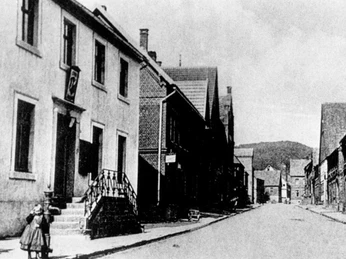 Das zweite Rathaus in der Schulstraße 1834-1947 Historisches schwarz-weiß Foto einer Straße mit Gebäuden und Mädchen im Vordergrund.