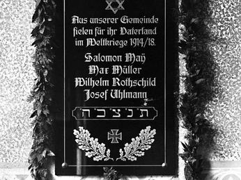 Gedenktafel 1. Weltkrieg Gedenktafel des Ersten Weltkriegs mit Namen gefallener Soldaten, verziert mit einem Kranz.