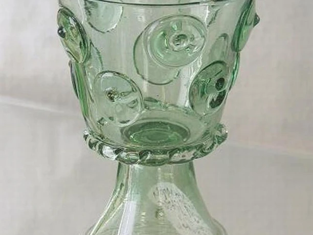 Waldglas, Glasmuseum Bad Driburg Ein gläserner Kelch mit dickem, transparentem Grün, verziert mit runden Glasnoppen auf dem Korpus.