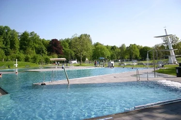 Rolandsbad Paderborn Ein modernes Freibad mit mehreren Schwimmbecken, grüner Umgebung und einem markanten Sprungturm.