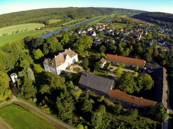 Blick ins Wesertal mit Schloss und Ort Wehrden Luftaufnahme von Schloss Wehrden und Umgebung, mit Weser und ländlichem Panorama im Hintergrund.