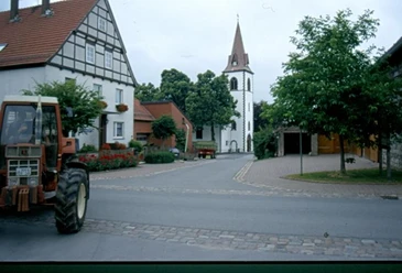 Kirche in Tietelsen Eine gotische Kirche mit spitzem Turm steht am Ende einer ruhigen, von Fachwerkhäusern flankierten Straße.