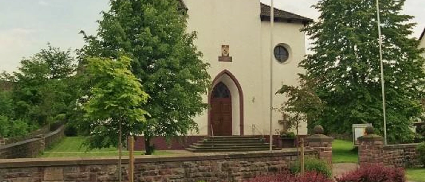 kath. Kirche in Amelunxen Katholische Kirche Amelunxen mit weißem Turm und grünem Dach, flankiert von Bäumen und Büschen.