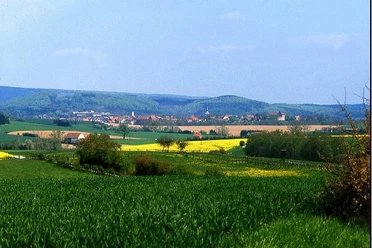 Weite Felder erstrecken sich vor der historischen Altstadt Blombergs, umgeben von sanften Hügeln.