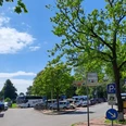 Parkplatz Strandterrassen mit Busparkplatz Parkplatz mit gekennzeichneten Flächen für Busse und Fahrräder, umgeben von grünen Bäumen.