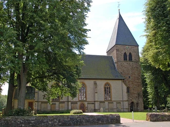 Stiftskirche in Stift Quernheim Stiftskirche in Stift Quernheim mit steinernem Glockenturm und umgebenden Laubbäumen im Sommer.