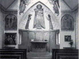 Innenansicht Antoniuskapelle Die Antoniuskapelle mit kunstvollen Fresken, Holzbänken und einem schlichten Altar in der Mitte.
