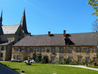 Kloster Herzebrock Klosteranlage mit historischen Gebäuden, spitzen Kirchtürmen und gepflegter Rasenfläche im Vordergrund.