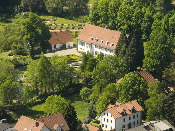 Luftbild des Kurparks Preußisch Oldendorf mit historischen Gebäuden und einer gepflegten Gartenanlage.
