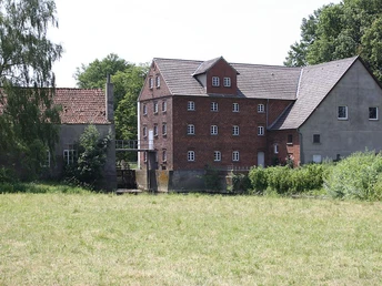 Nienburg an der Else Historische Backsteinmühle in Nienburg an der Else, umgeben von saftigem Grün und alten Bäumen.