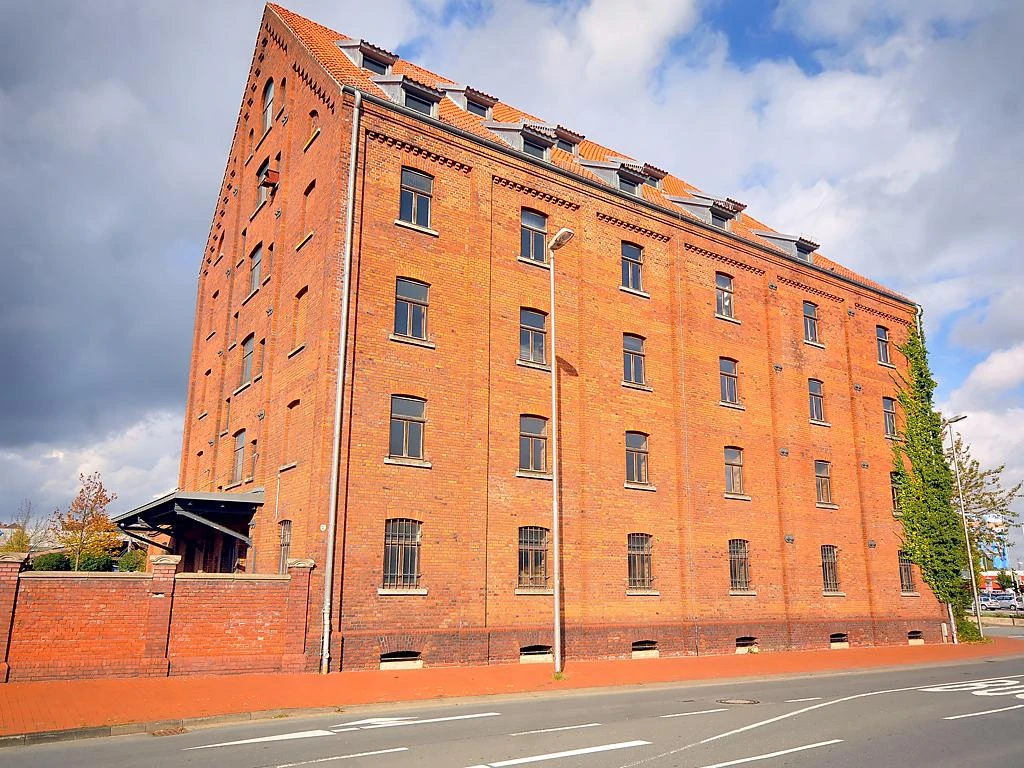 Tabakspeicher Roter Backsteinbau des Tabakspeichers unter blauem Himmel, vier Fensterreihen und Ziegeldach.