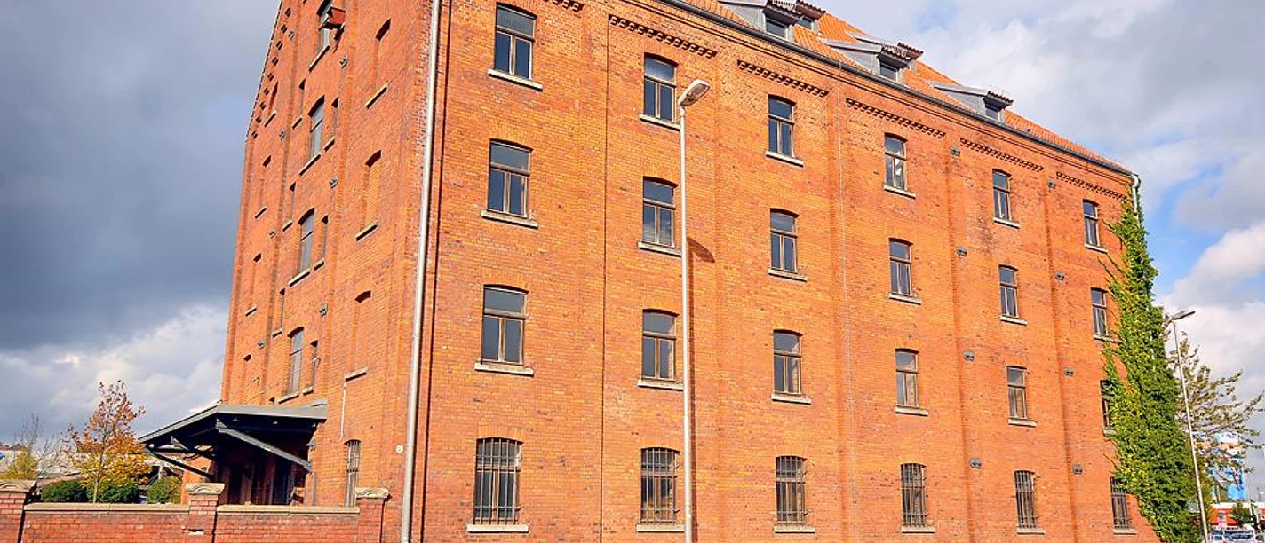 Tabakspeicher Roter Backsteinbau des Tabakspeichers unter blauem Himmel, vier Fensterreihen und Ziegeldach.