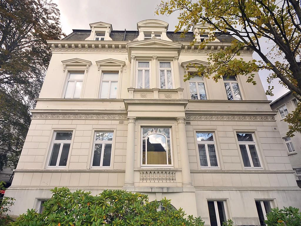 Villa der Familie Steinmeister Eine weiße, historische Villa mit symmetrischen Fenstern und dekorativen Fassadenelementen.