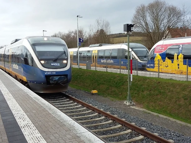 Drei Züge der NordWestBahn an Bahnsteigen